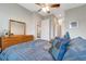 This bedroom features a ceiling fan, wood dresser, plush carpet, and a well lit closet at 2335 Symphony Cir, St Cloud, FL 34771