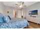 Neutral bedroom featuring a ceiling fan, hardwood floors, and a large TV on the wall at 2335 Symphony Cir, St Cloud, FL 34771