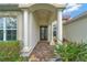 Inviting front entrance with elegant columns, a brick pathway, and lush landscaping at 2335 Symphony Cir, St Cloud, FL 34771