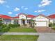 Charming single-story home boasts a red tile roof, manicured lawn and inviting curb appeal at 2335 Symphony Cir, St Cloud, FL 34771