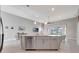 Bright kitchen island with stainless steel appliances and pendant lighting is open to the living area at 2335 Symphony Cir, St Cloud, FL 34771