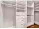 Bright walk-in closet with custom white shelving, drawers, and ample hanging space for optimal organization at 2335 Symphony Cir, St Cloud, FL 34771