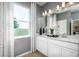 Contemporary bathroom with double vanity, large mirror, and patterned window treatments at 2547 Great Heron Ave, St Cloud, FL 34773