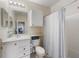 Bright bathroom features a white vanity, toilet, cabinet, and a shower with a striped curtain at 2549 Maitland Crossing Way # 306, Orlando, FL 32810