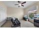 The carpeted room has a futon, a ceiling fan, large windows, and a TV at 2549 Maitland Crossing Way # 306, Orlando, FL 32810