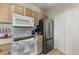 Galley kitchen with white appliances and light wood cabinets at 2549 Maitland Crossing Way # 306, Orlando, FL 32810