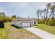 Exterior view of home featuring a driveway, well maintained yard, and lush trees at 2596 Sw 146 St, Ocala, FL 34473