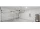 Spacious garage with roll-up door, white brick walls, and concrete flooring at 2596 Sw 146 St, Ocala, FL 34473