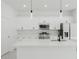 Modern kitchen featuring stainless steel appliances, white cabinets, and a large quartz island at 2596 Sw 146 St, Ocala, FL 34473