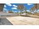 Expansive backyard with concrete patio, shed, and lush trees under a sunny sky at 2685 Groveland Ave, Deltona, FL 32725