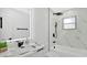 Bathroom featuring modern finishes with black hardware, marble countertops, a bathtub, and a glass shower at 2685 Groveland Ave, Deltona, FL 32725