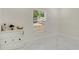 Bright, simple bedroom with a large window, white dresser, and white marble tile at 2685 Groveland Ave, Deltona, FL 32725