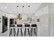 Modern kitchen features an island with seating, pendant lighting, and stainless steel appliances at 2685 Groveland Ave, Deltona, FL 32725
