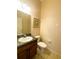 Traditional half bath features vanity with dark wood cabinets, sink and a white toilet at 2840 Roccella Ct, Kissimmee, FL 34747