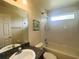 Bathroom features a combined shower-tub, white fixtures, and neutral tile flooring at 2840 Roccella Ct, Kissimmee, FL 34747