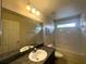 Well-lit bathroom with single sink, large mirror and bathtub with shower at 2840 Roccella Ct, Kissimmee, FL 34747