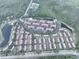 A captivating aerial view of a community with red-tiled roofs surrounded by forest, lakes, and an adjacent shopping center at 3020 Red Ginger Rd, Kissimmee, FL 34747