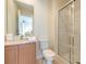 Bright bathroom with a vanity, toilet, and glass enclosed shower at 3020 Red Ginger Rd, Kissimmee, FL 34747