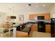 View of kitchen and dining area with wooden cabinetry, black appliances, and stylish accents at 3020 Red Ginger Rd, Kissimmee, FL 34747