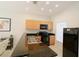 Well-lit kitchen with stainless steel sink and black appliances at 3020 Red Ginger Rd, Kissimmee, FL 34747