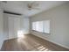 Bright bedroom featuring a ceiling fan, wood-look floors, and a closet, creating a comfortable and functional space at 30542 Hoylake St, Sorrento, FL 32776