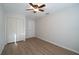 Bedroom with wood-look floors, a ceiling fan, closet, creating a comfortable and functional space at 30542 Hoylake St, Sorrento, FL 32776