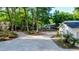 Wide, gravel driveway leading to a charming home nestled among mature trees and lush landscaping at 30542 Hoylake St, Sorrento, FL 32776