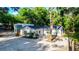 Charming home with a gravel driveway and a detached garage surrounded by lush greenery at 30542 Hoylake St, Sorrento, FL 32776