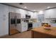 Modern kitchen with stainless steel appliances, white cabinetry, and wood-look flooring at 30542 Hoylake St, Sorrento, FL 32776