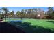 A community basketball court featuring white lines, blue insets, and hoops at both ends with tennis courts in the background at 320 Remington Dr, Oviedo, FL 32765
