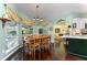 Bright dining room with hardwood floors open to the kitchen, large windows, and pool view at 320 Remington Dr, Oviedo, FL 32765