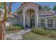 Elegant home exterior featuring a grand entrance with columns, arched windows, and well-manicured landscaping at 320 Remington Dr, Oviedo, FL 32765