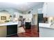Modern kitchen featuring white cabinets, stainless steel appliances, an island, and dark hardwood floors at 320 Remington Dr, Oviedo, FL 32765