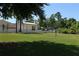 A spacious backyard featuring a volleyball court, with a white fence and ample green space for outdoor activities and enjoyment at 320 Remington Dr, Oviedo, FL 32765