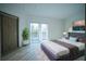 Bright bedroom with sliding glass doors leading to a balcony, wood floors, and closet at 32325 State Road 44, Eustis, FL 32736