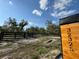 Welcoming property entrance with wooden address number sign, black fence, and a decorative gate at 32325 State Road 44, Eustis, FL 32736