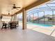 Screened patio area with dining set overlooking the sparkling pool and adjacent spa at 330 Rosso Dr, Davenport, FL 33837