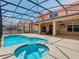 A beautiful pool and spa are enclosed with a black screen and are adjacent to an outdoor dining area at 330 Rosso Dr, Davenport, FL 33837
