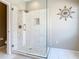 Modern shower with white tile, glass enclosure, and decorative wall accent, creating a luxurious bathing experience at 330 Rosso Dr, Davenport, FL 33837