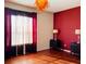 Bedroom featuring red walls, window with curtains, wood floors, and dual dressers with lamps at 3368 Robert Trent Jones Dr # 40808, Orlando, FL 32835
