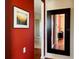 Hallway featuring a decorative wall mirror, artwork, and contrasting paint that adds visual interest at 3368 Robert Trent Jones Dr # 40808, Orlando, FL 32835