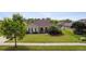 Well-maintained home exterior with a green lawn, mature trees, and blue shutters at 350 Black Springs Ln, Winter Garden, FL 34787