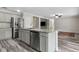 Modern kitchen island with stainless steel appliances, gray cabinets and gray wood-look flooring at 350 Black Springs Ln, Winter Garden, FL 34787