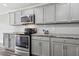 Modern kitchen featuring gray cabinets, stainless steel appliances, and granite countertops at 350 Black Springs Ln, Winter Garden, FL 34787