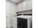 Modern laundry room with sleek, front-loading washer and dryer and built-in cabinets at 350 Black Springs Ln, Winter Garden, FL 34787