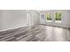 Bright living room with gray wood-look flooring, a decorative front door, and natural light from several windows at 350 Black Springs Ln, Winter Garden, FL 34787