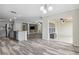 Open-concept living room featuring wood-look flooring, stone accent wall, and access to the lanai at 350 Black Springs Ln, Winter Garden, FL 34787