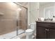 Bathroom showcasing a walk-in shower with glass doors and dark cabinetry at 3838 Lana Ave, Davenport, FL 33897