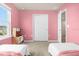 Bright bedroom with two beds, pink walls, and a play kitchen by the window at 3838 Lana Ave, Davenport, FL 33897