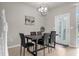 Modern dining area with a large table, stylish chairs, and an elegant chandelier, near a staircase at 3838 Lana Ave, Davenport, FL 33897